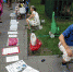 有的坐在小板凳上，面前摆着一块纸板；有的捧着纸板。  本文图片均为北京晚报 图 - 新浪吉林