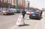 商贩将“收车”字样提示牌摆放到机动车道招揽生意。李子涵 摄 - 新浪吉林